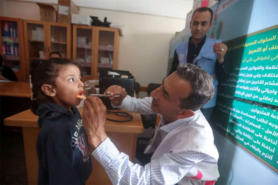 Dokter Palestina, Hassan Zain al Din, memberikan perawatan terhadap seorang anak yang mengungsi pada Oktober 2023. (Sumber: REUTERS/Ahmed Zakot) - Image