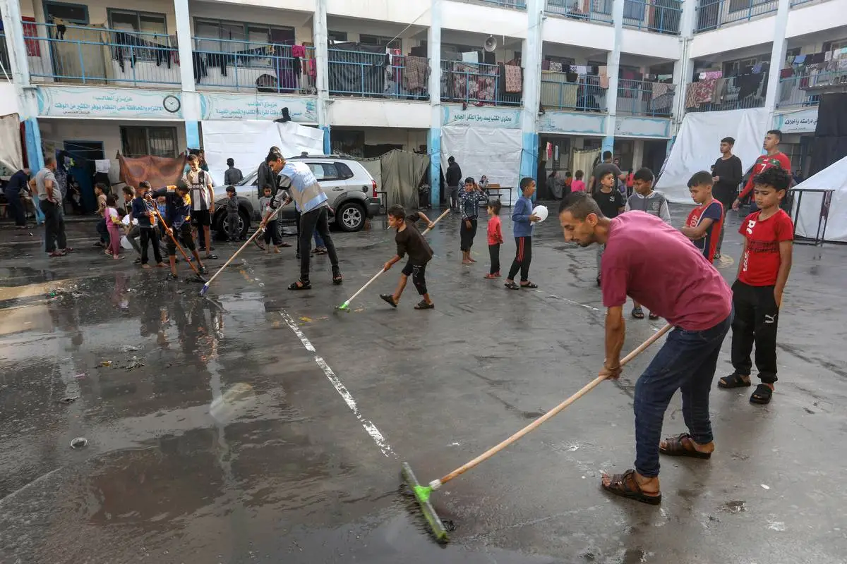 Warga Palestina yang berlindung di sekolah UNRWA berjuang menghadapi hujan lebat, angin kencang, dan banjir saat serangan Israel berlanjut pada hari ke-39 di Rafah, Gaza, Selasa (14/11). - Image