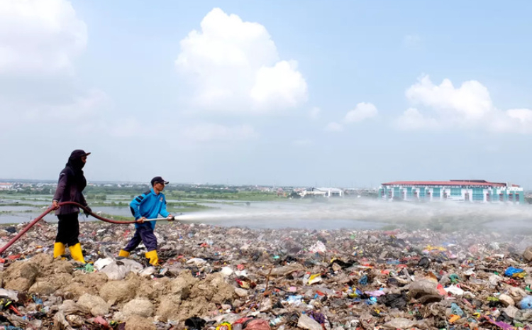 Petugas melakukan penyemprotan di area TPA Benowo, Surabaya, Senin (13/11). Selama Piala Dunia U-17 penyemprotan dilakukan lebih intens untuk menghilangkan bau sampah. (SURYANTO/RADAR SURABAYA) - Image