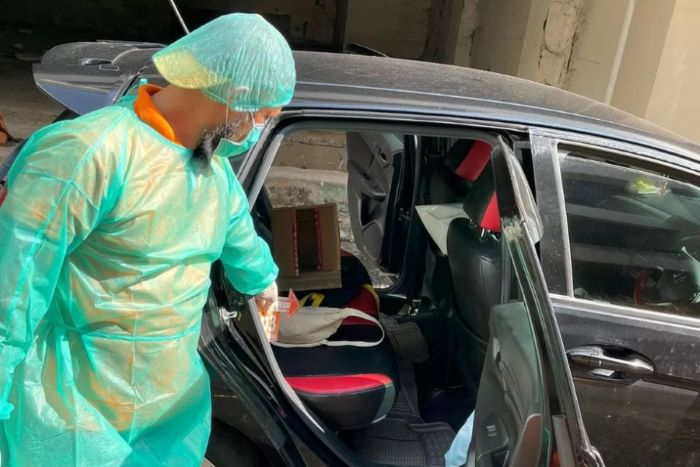 Polisi saat olah TKP di mobil Caroline. - Image