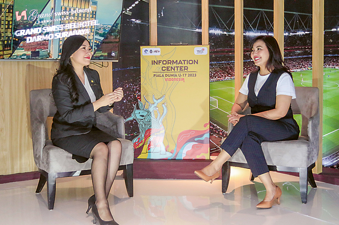 SPOT KHUSUS: Assistant Marcomm Manager Grand Swiss-Belhotel Darmo Gitareta Megantari (kiri) berbincang dengan tamu hotel di media center Piala Dunia U-17 2023 kemarin (20/11). - Image