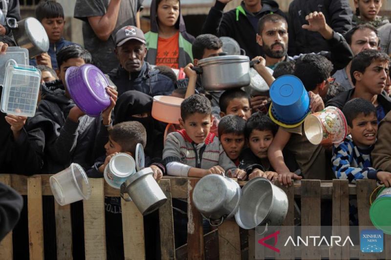 Anak-anak dan orang dewasa menunggu di pagar untuk mendapatkan bantuan makanan di Kota Rafah di Jalur Gaza pada 19 November 2023. ANTARA/Rizek Abdeljawad/Xinhua/tm (Rizek Abdeljawad/Xinhua) - Image