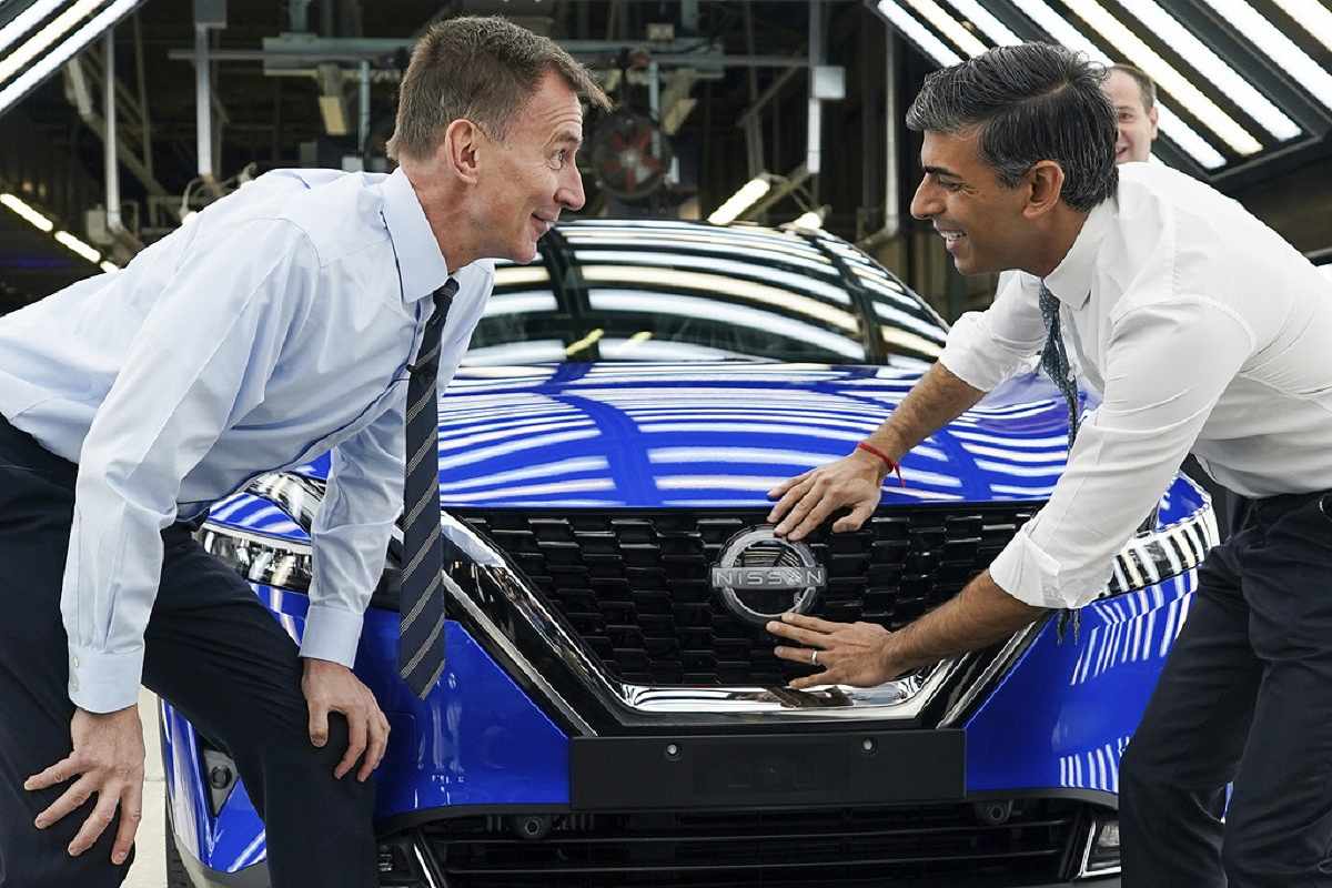 Perdana Menteri Inggris Rishi Sunak (kanan) dan Menteri Keuangan Jeremy Hunt menempelkan lencana Nissan pada mobil saat mereka mengunjungi produsen mobil Nissan, di Sunderland, Inggris, Jumat (24/11). - Image