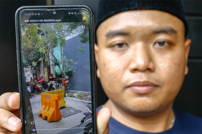 Abdul Muid Kafi, anggota Satpol PP Surabaya, menunjukkan rekaman video penganiayaan saat ditemui di rumahnya di Banyu Urip, Sabtu (2/12). - Image