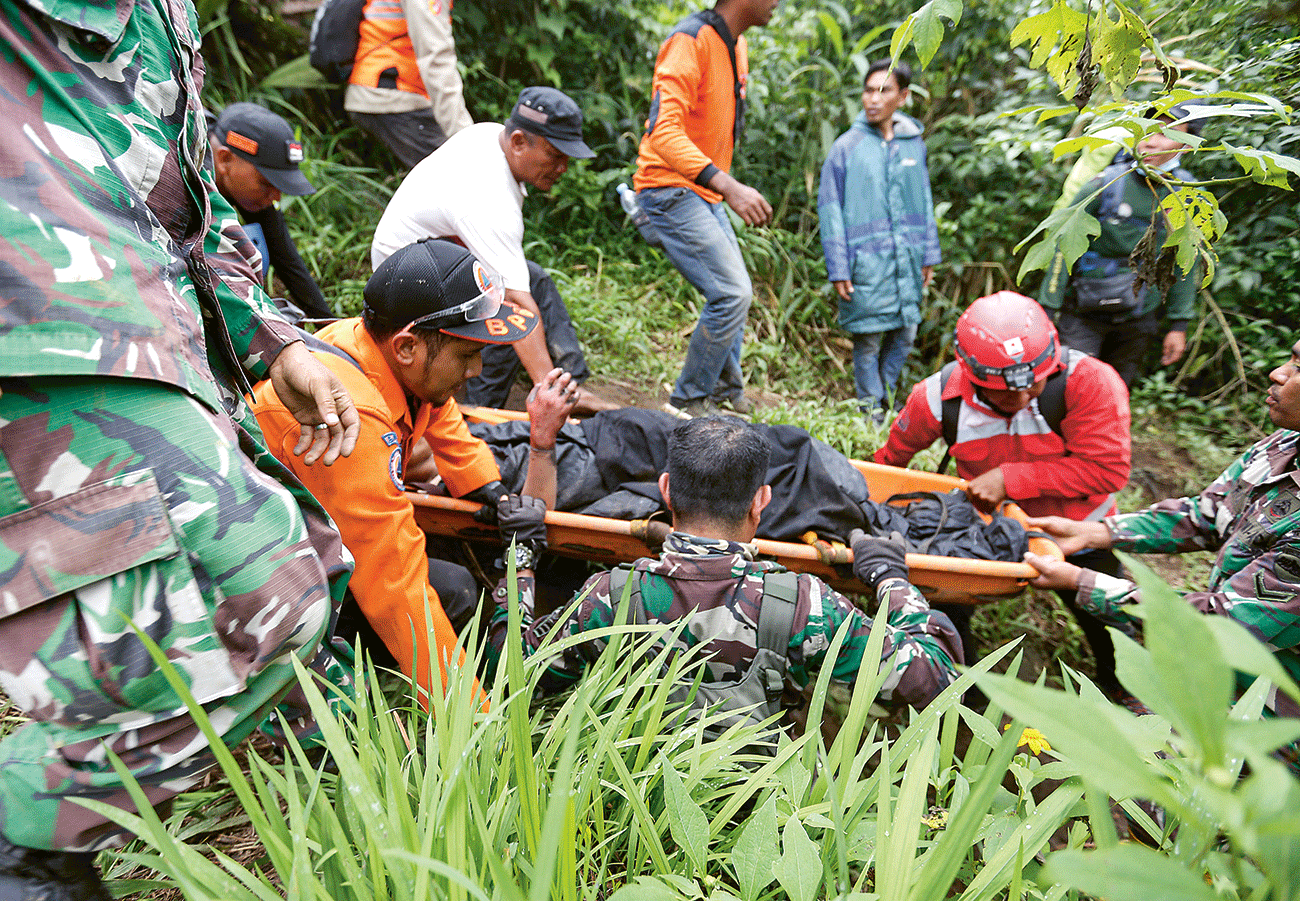 MISI PENYELAMATAN: Tim SAR mengevakuasi korban meninggal dari Gunung Marapi Senin (4/12). - Image