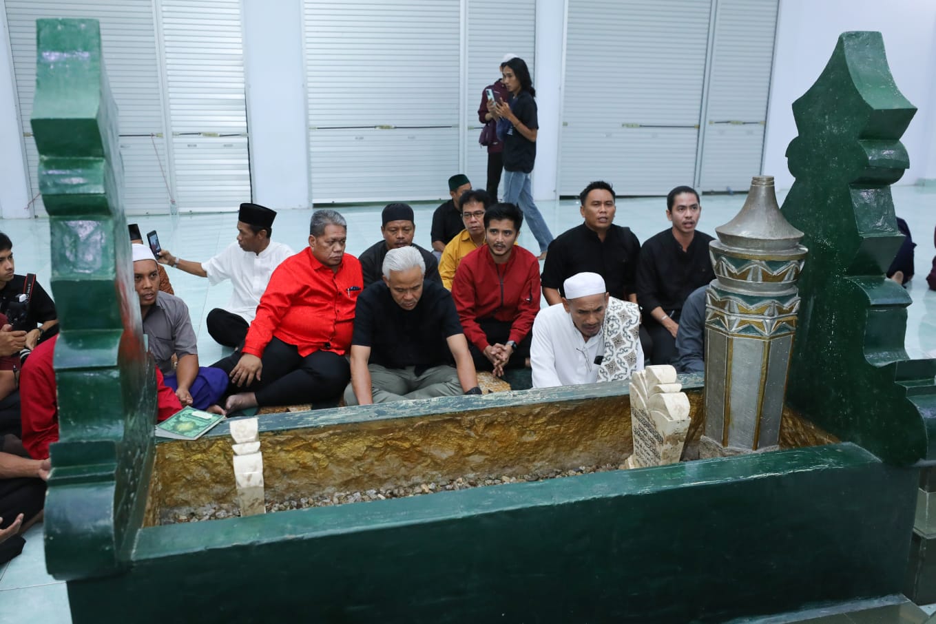 Calon presiden Ganjar Pranowo berziarah ke makam Al-Habib Idrus bin Salim Al-Jufri atau lebih dikenal dengan Sayyid Idrus bin Salim Al-Jufri atau Guru Tua di di komplek Masjid Alkhairaat. - Image