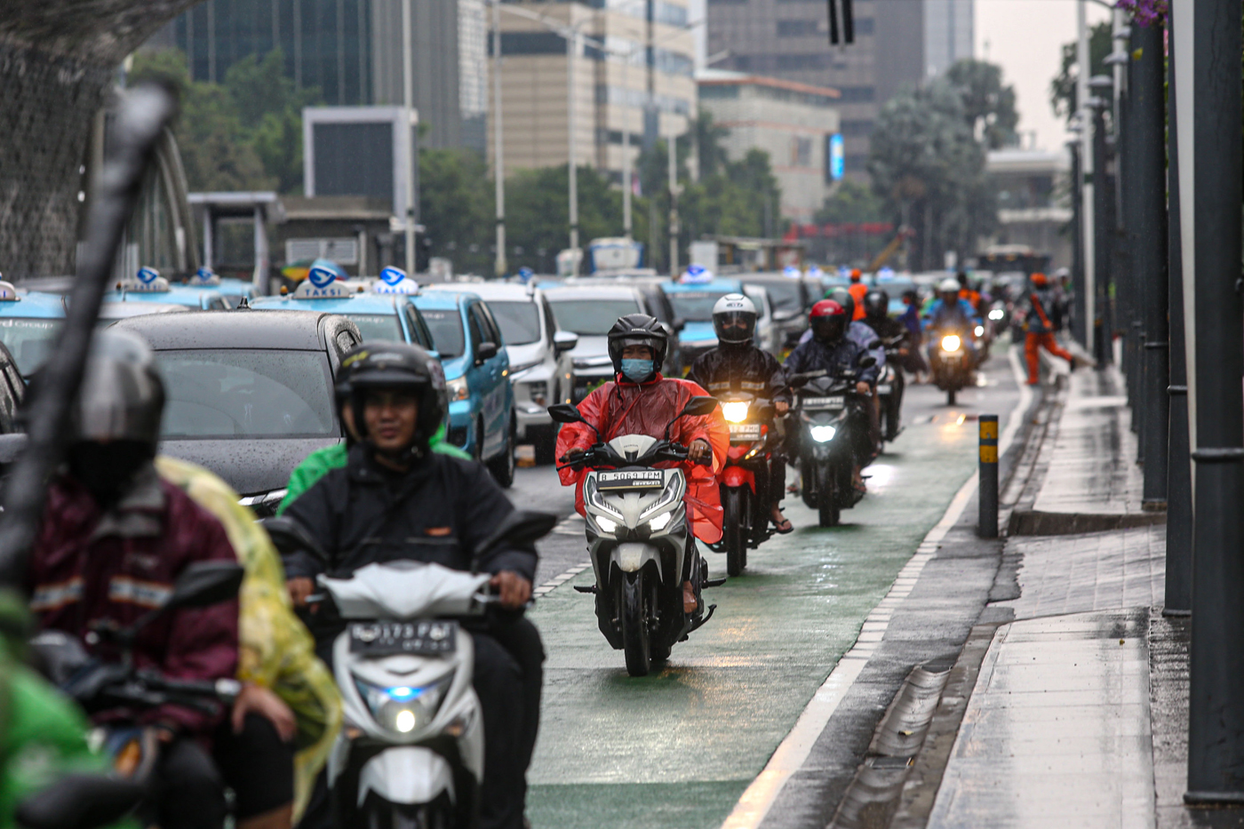 Warga mengunakan payung saat hujan turun di kawasan Bundara Hotel Indonesia, Jakarta, Jumat (8/12/2023). - Image
