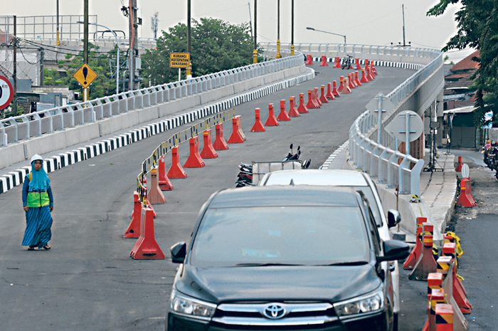 UJI COBA: Petugas memasang traffic cone di flyover Krian yang tuntas terbangun kemarin (11/12). Mulai hari ini, pemotor sudah bisa melewati flyover. - Image