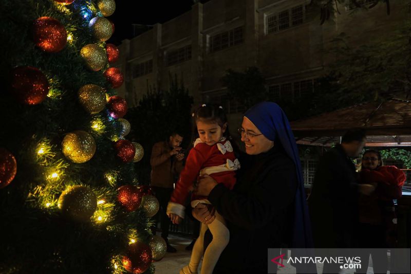 Warga menghadiri upacara penyalaan pohon Natal di sebuah gereja di Gaza City, Palestina (18/12/2021). - Image