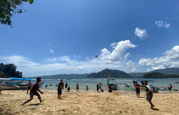 SUKA: Wisatawan menikmati bermain voli pantai di dekat JLS Trenggalek-Tulungagung. (DHARAKA R. PRADANA/RADAR TRENGGALEK) - Image