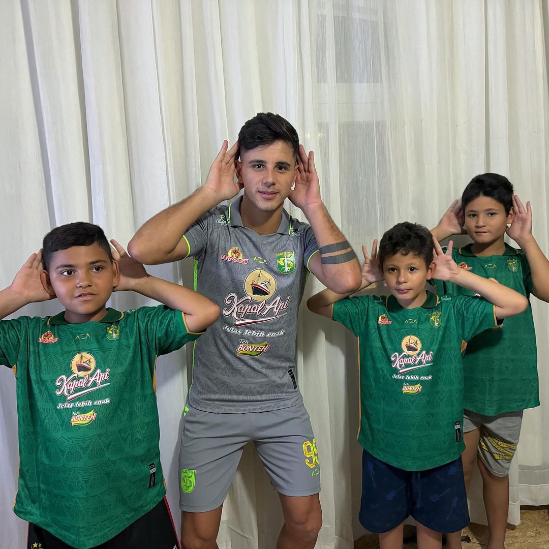 Bruno Moreira ketika membagikan jersey Persebaya Surabaya ke keponakan dan keluarganya dan mereka tampak senang serta antusias. - Image