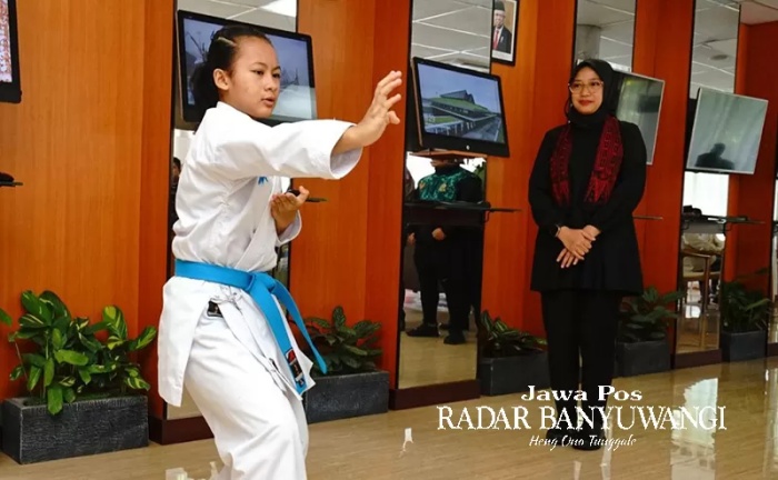 Aldhea Azarina Bharata memperagakan jurus karate di hadapan Bupati Ipuk Fiestiandani di Lounge Pelayanan Publik, Kantor Pemkab Banyuwangi, Senin (20/11). (Dini for Radar Banyuwangi) - Image