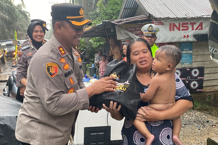 Kapolres Rokan Hulu AKBP Budi Setiyono saat memberikan bantuna ke korban banjir. - Image