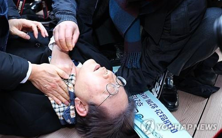 ee Jae-myung, pemimpin oposisi utama Partai Demokrat, berbaring setelah dia diserang oleh penyerang di sisi kiri lehernya saat berkunjung ke lokasi pembangunan bandara ./ - Image