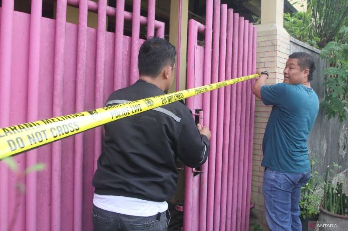 Polisi memasang garis polisi di pagar sebuah rumah yang menjadi tempat kejadian perkara (TKP) kasus pembunuhan disertai mutilasi di Jalan Serayu, Kota Malang, Minggu (31/12). - Image