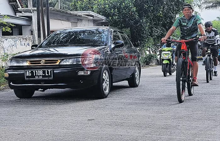 Pengguna jalan melintas di salah satu ruas jalan beton rabat di kabupaten Blitar. - Image