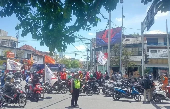 Massa buruh sempat menutup simpang empat Jalan Tembaan. Mereka hendak menuju Polrestabes Surabaya, namun aksi itu diurungkan dan berbalik ke Polda Jatim./(GUNTUR I/RADAR SURABAYA) - Image