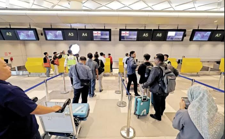 Petugas dari maskapai memeriksa dokumen kelengkapan calon penumpang sebelum mencetak tiket fisik./ (Foto: Wahyu Adji/JPRK) - Image