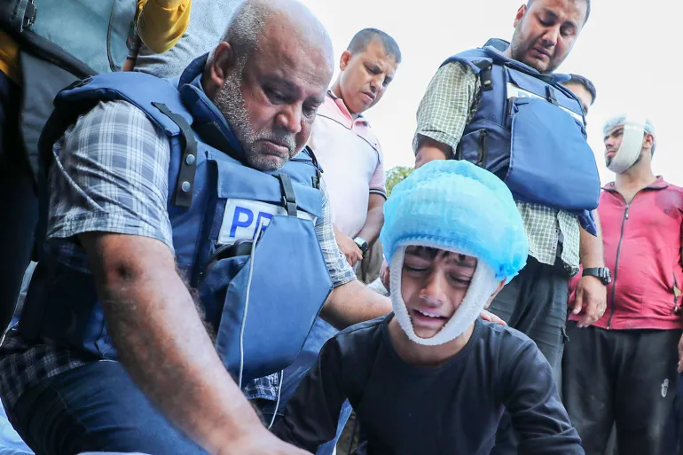 Wael Dahdouh, tengah, dan putra bungsunya Yehia, 12, berduka atas kematian istri, putra, putri, dan cucunya dalam serangan Israel di kamp pengungsi Nuseirat, 26 Oktober 2023 - Image