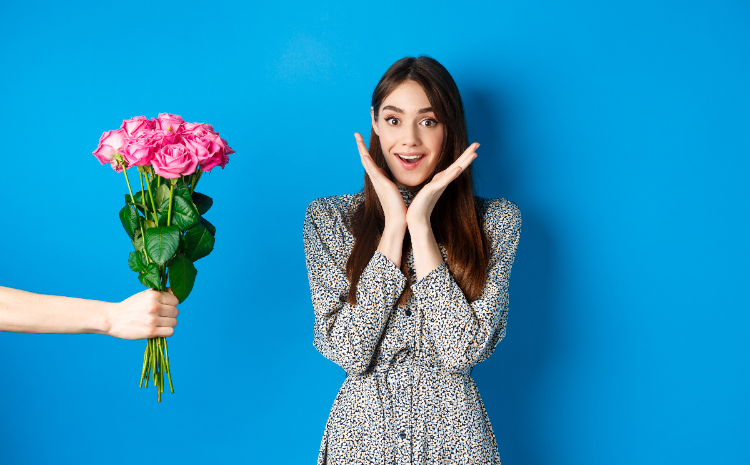 Seorang wanita diberi buket bunga tersenyum senang. (Sumber foto : Freepik) - Image