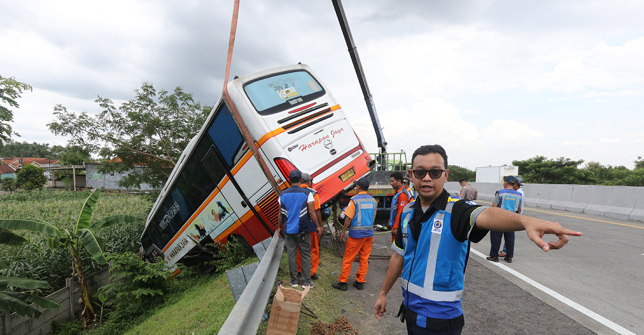 HILANG KENDALI: Bus Harapan Jaya yang nyungsep di Km 718 tol Surabaya-Mojokerto kemarin (18/1). - Image