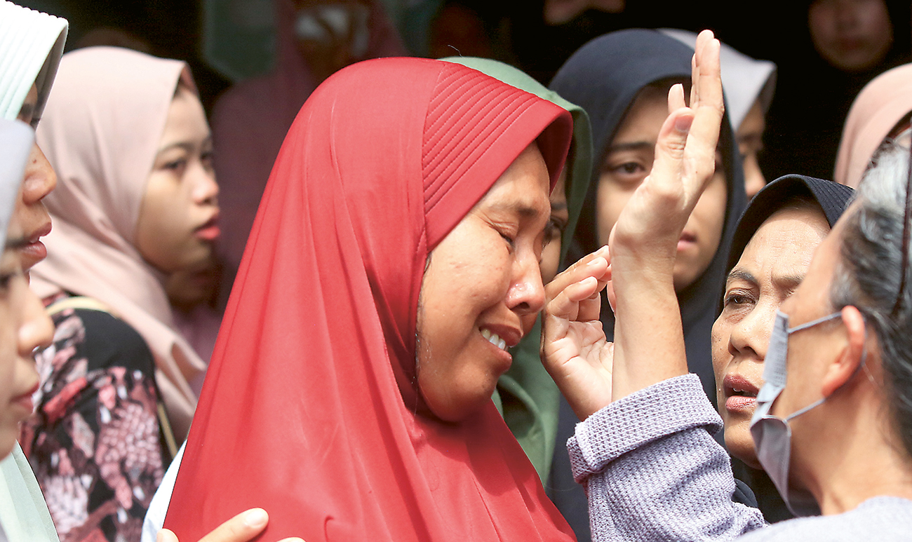 DUKA IBUNDA: Royidah, ibunda Nabil Azfa Putra Dyah, tak kuasa menahan tangis saat jenazah putranya akan disemayamkan di rumah duka di kawasan Jl Yos Sudarso, Pucang, Sidoajo, kemarin. - Image