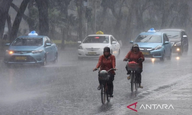 Dua orang pesepeda menembus hujan lebat di jalan Merdeka Selatan, Jakarta. (sumber: ANTARA FOTO/Wahyu Putro A/foc) - Image