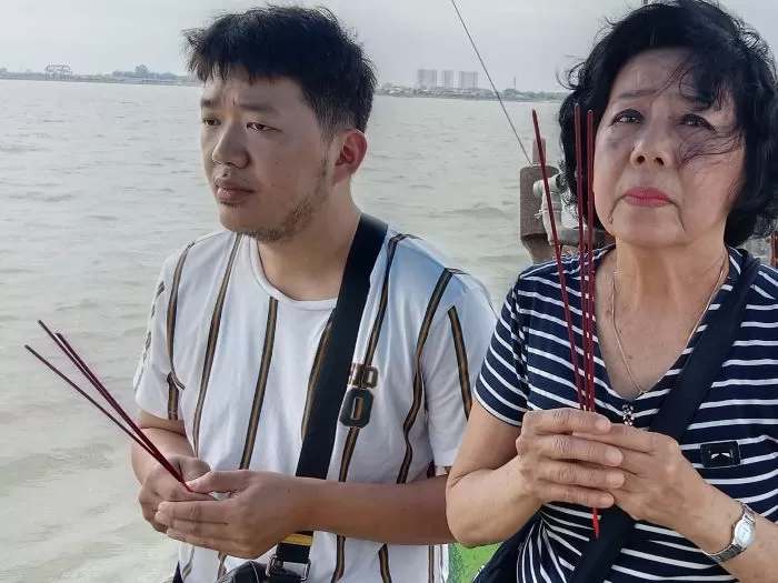 Umat Tri Dharma melakukan ritual di atas kapal sebelum prosesi larung di Selat Madura. - Image