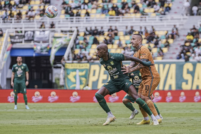LIBUR LAGI: Paulo Henrique menjaga bola dari rebutan pemain Bhayangkara FC, Radja Nainggolan. Liga 1 akan libur lagi hingga dua pekan ke depan. (Persebaya) - Image
