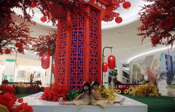 Dua anak berpose dengan latar belakang dekorasi Imlek dengan tema perpaduan Asia dan Eropa di Ciputra World Surabaya, Senin (5/2). (ANDY S/RADAR SURABAYA) - Image