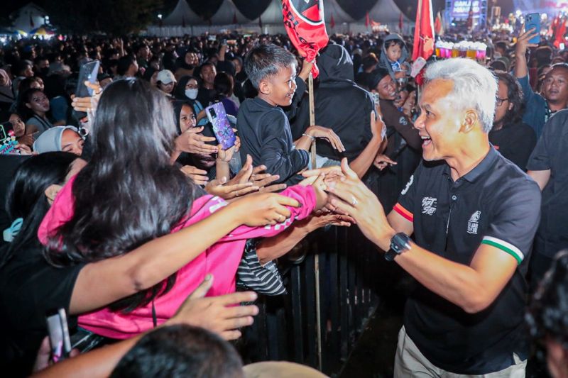 Capres nomor urut 3 Ganjar Pranowo (kanan) saat menyapa warga dalam acara "Pesta Rakyat Ganjar-Mahfud" yang diselenggarakan Sahabat Ganjar, di Lapangan Merdeka, Delanggu, Kabupaten Klaten, Jawa Tengah - Image