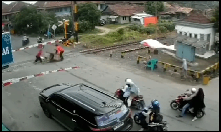 Viral video yang memperlihatkan deti-detik pemotor terjatuh pada saat menerobos palang pintu kereta api di media sosial Instagram. (Istimewa) - Image