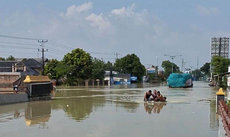 Sejumlah warga tengah mendorong sepeda motor yang terendam air selama beberapa hari di rumahnya./(ANTARA/Akhmad Nazaruddin Lathif) - Image