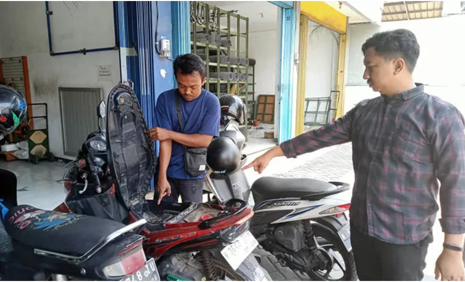 OLAH TKP: Rizky Hariadi bersama petugas kepolisian di depan toko bangunan milik UD Jayadi Wijaya di Jalan erlangga. (Polres Pasuruan Kota) - Image