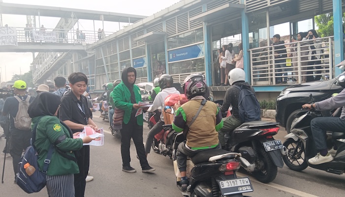 Massa aksi Universitas Negeri Jakarta (UNJ) saat membagikan selebaran di depan hal bus UNJ Rawamangun. - Image