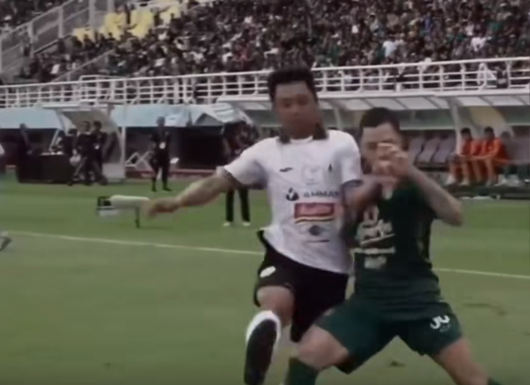 Duel perebutan bola antara Wahyudi Hamisi dan Robson Duarte. - Image