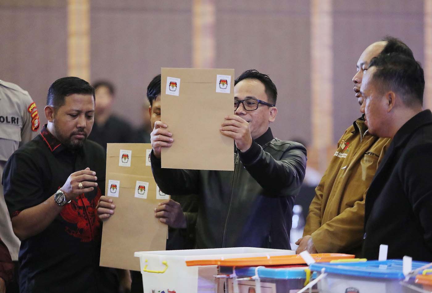 KPU Provinsi DKI Jakarta membuka kotak berisi berkas rekap hasil penghitungan suara tingkat Kota saat rapat pleno rekapitulasi tingkat provinsi penghitungan suara Pemilu 2024, Kamis (7/3/2024). - Image