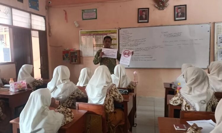 Kepala SMPN 1 Gresik, Berry Avita Prasetya sedang melakukan sosialisasi larangan penggunaan sepeda listrik ke sekolah bagi siswa./Dok Radar Gresik - Image