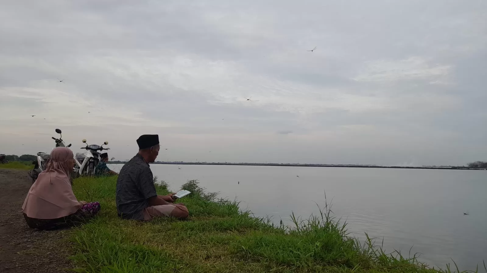 Warga Porong, Sidoarjo yang sedang melakukan tradisi nyekar jelang Ramadhan di tanggul lumpur. / M Saiful Rohman/Radar Sidoarjo - Image