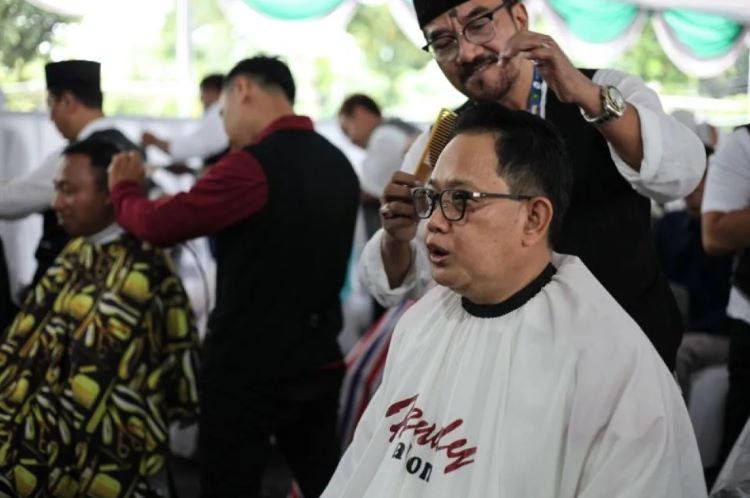 Pj Gubernur Jatim Adhy Karyono (kanan) saat mendapatkan pelayanan potong rambut gratis yang diselenggarakan oleh Masjid Al Akbar Surabaya, Senin (11/3/2024). ANTARA/Didik Suhartono. - Image