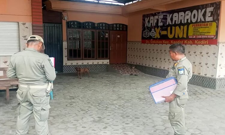 Petugas Satpol PP Kabupaten Kediri saat menempelkan SE tentang penutupan tempat hiburan selama Ramadhan di salah satu tempat karaoke di Kecamatan Kandat./Satpol PP Kabupaten Kediri - Image