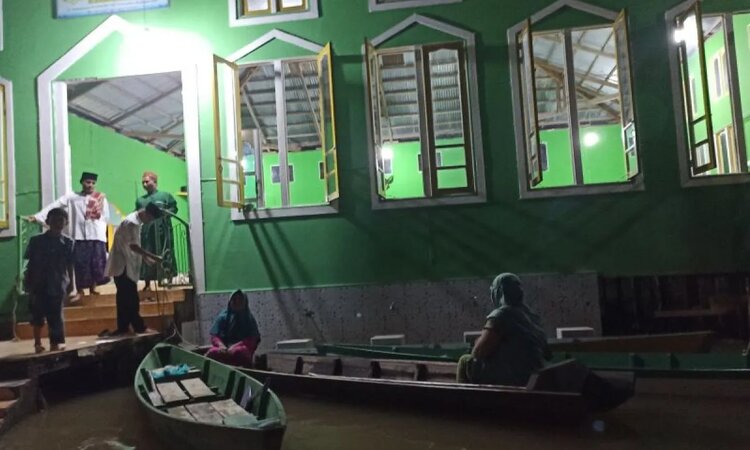 Warga Teluk Barak, Kecamatan Putussibau Selatan, Kabupaten Kapuas Hulu terpaksa menggunakan perahu untuk pergi melaksanakan ibadah sholat tarawih hari pertama di surau./ - Image