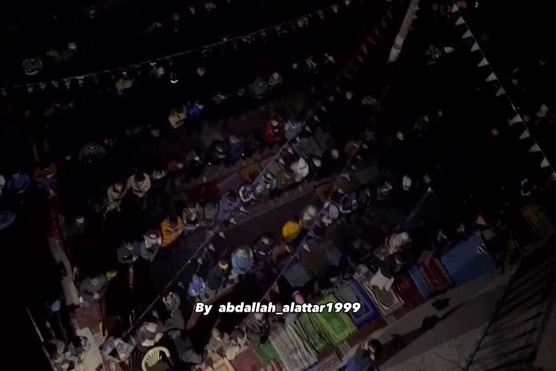 Warga Gaza melaksanakan sholat tarawih di sekitar reruntuhan bangunan akibat serangan Israel. - Image