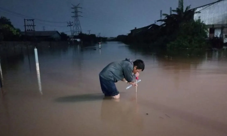 Petugas mengukur ketinggian banjir di jalur rel kereta api di wilayah Daop 4 Semarang, sehingga tidak bisa dilalui pada Kamis (14/3). (Antara) - Image