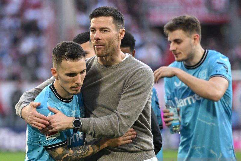 Bek Bayer Leverkusen asal Spanyol #20 Alejandro Grimaldo (kiri) bereaksi dengan pelatih kepala asal Spanyol Bayer Leverkusen Xabi Alonso. (AFP) - Image