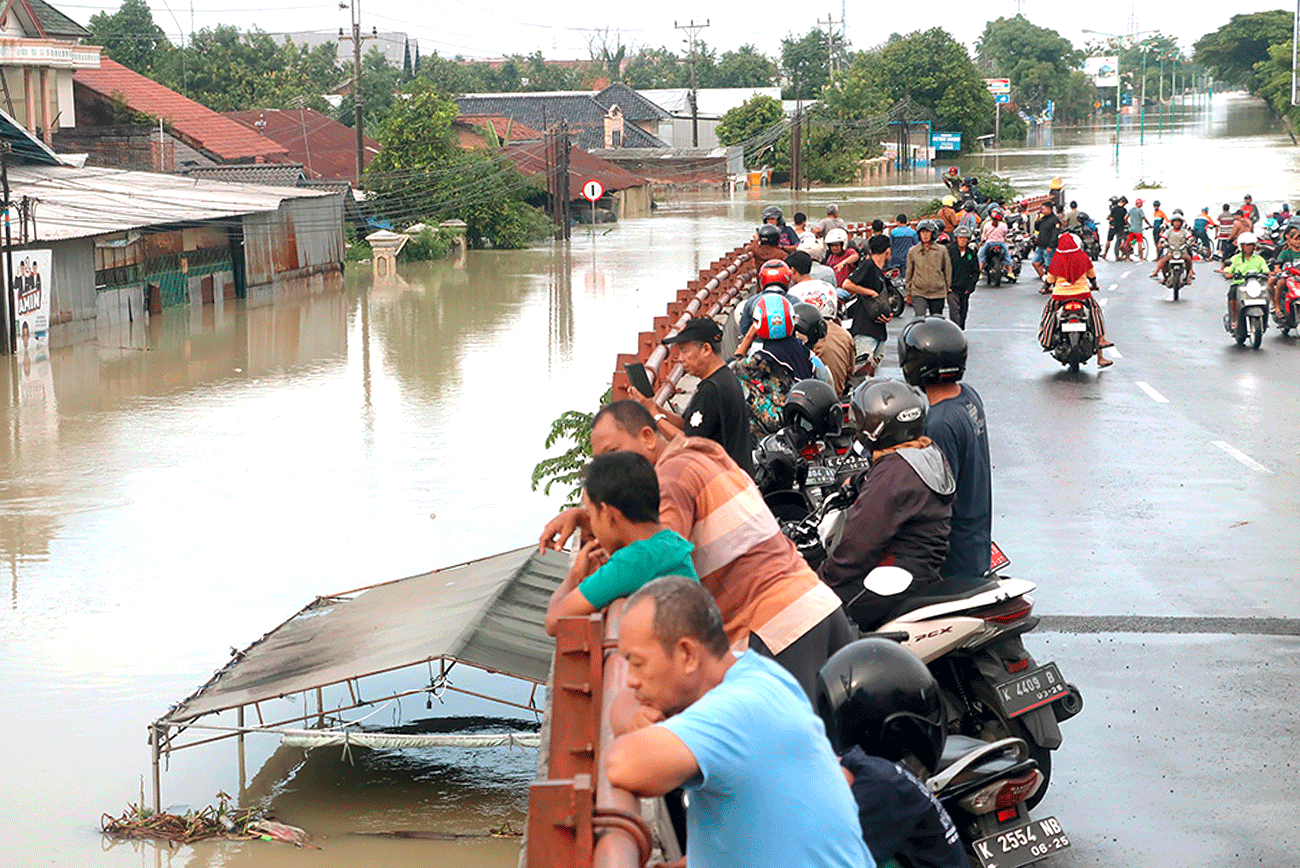 AKSES TERGANGGU: Tanggul Sungai Wulan di Duku Norowito, Desa Ketajung, Kecamatan Karanganyar, Demak, jebol, Minggu (17/3). Akibatnya, jalan pantura Demak-Kudus tak bisa dilalui karena banjir. - Image