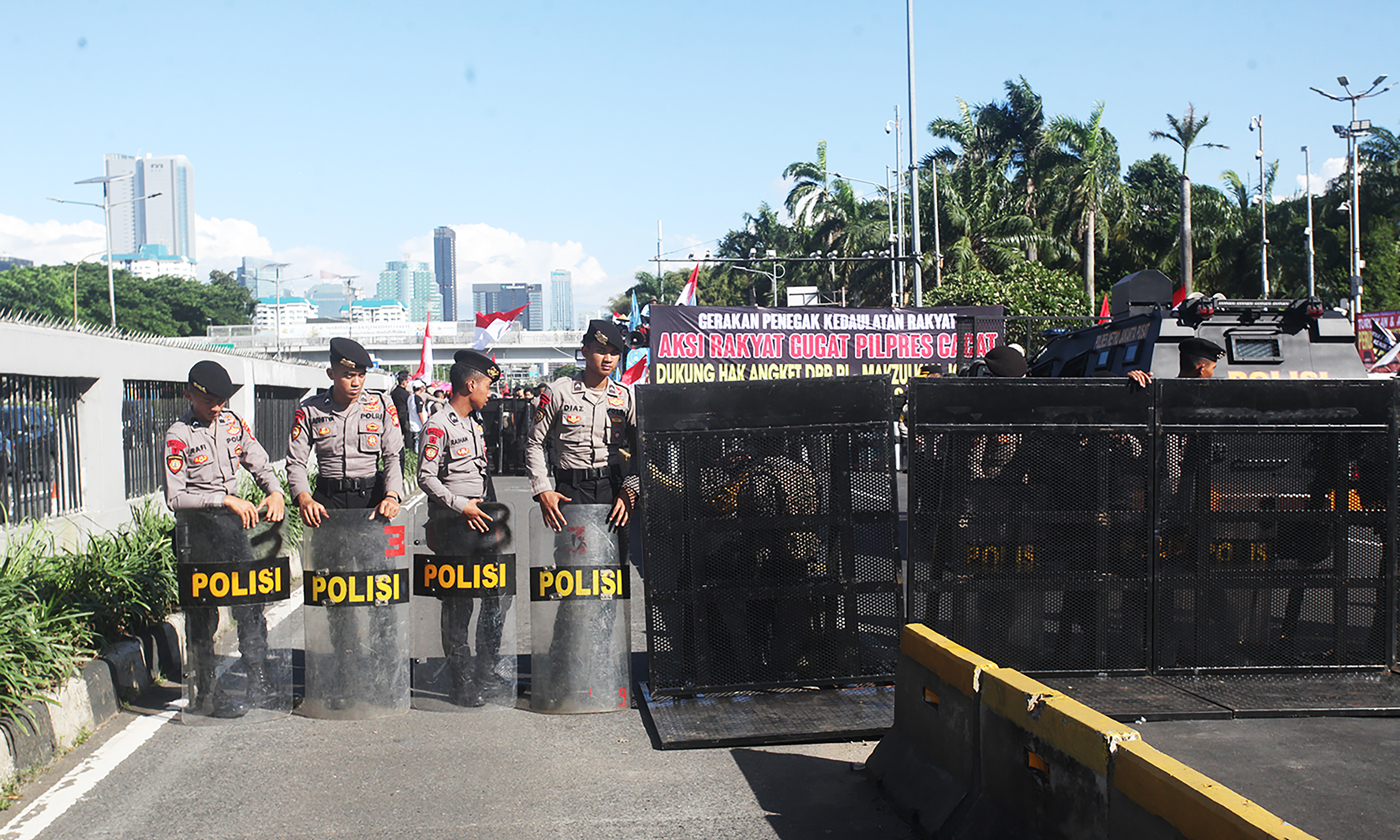 Aparat kepolisian berjaga saat massa berdemonstrasi menyampaikan aspirasinya di depan Gedung DPR, Se
