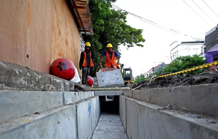 BIAR RAPI: Pekerja menyelesaikan box culvert untuk penempatan kabel utilitas bawah tanah di Jalan Kembang Jepun, Surabaya, Kamis (21/3). (suryanto/radar surabaya) - Image