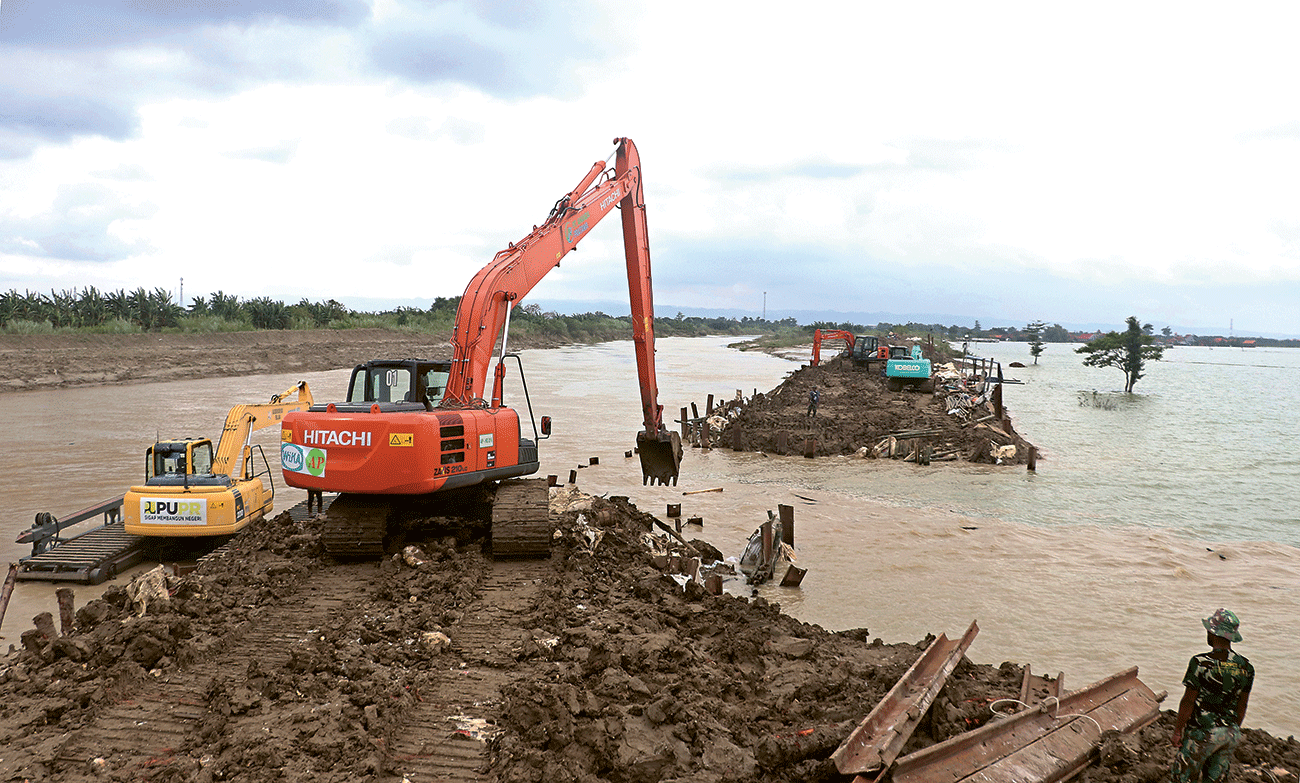 KERJA KERAS: Perbaikan tanggul Sungai Wulan menggunakan alat berat dari BBWS Pemali Juana dengan dibantu petugas TNI di Dukuh Norowito Ketanjung, Karanganyar, Demak, Kamis (21/3). - Image
