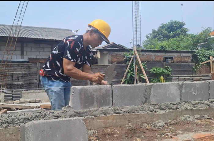 Proses penyusunan batako yang berasal dari limbah FABA (Fly Ash dan Bottom Ash) hasil dari sisa pembakaran batu bara di PLTU Lontar, Banten menjadi gardu distribusi listrik. - Image